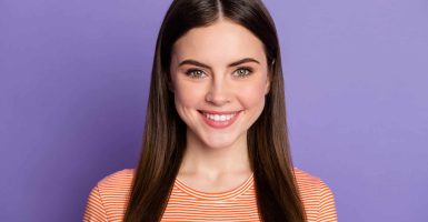 Closeup photo of attractive pretty lady beaming smile long brown straight, hairstyle wear casual orange striped t-shirt isolated pastel purple color background